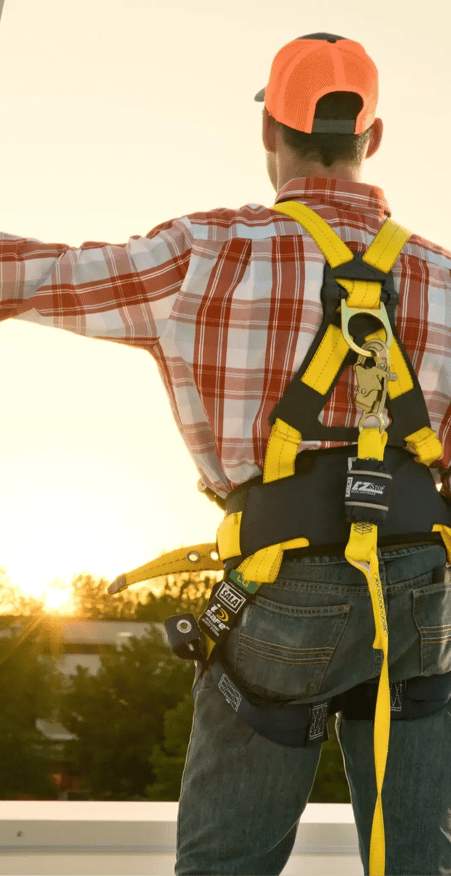 Worker on rooftop with fall protection PPE